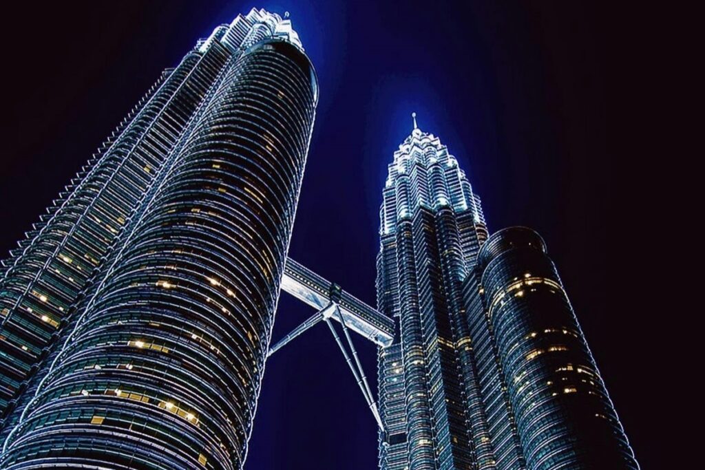 Gambar ini menampilkan Menara Petronas, tanda tanya kebanggaan Malaysia, yang berseri - seri di malam hari. Struktur megah dengan lampu - lampu yang terang mencipta pemandangan yang menakjubkan.